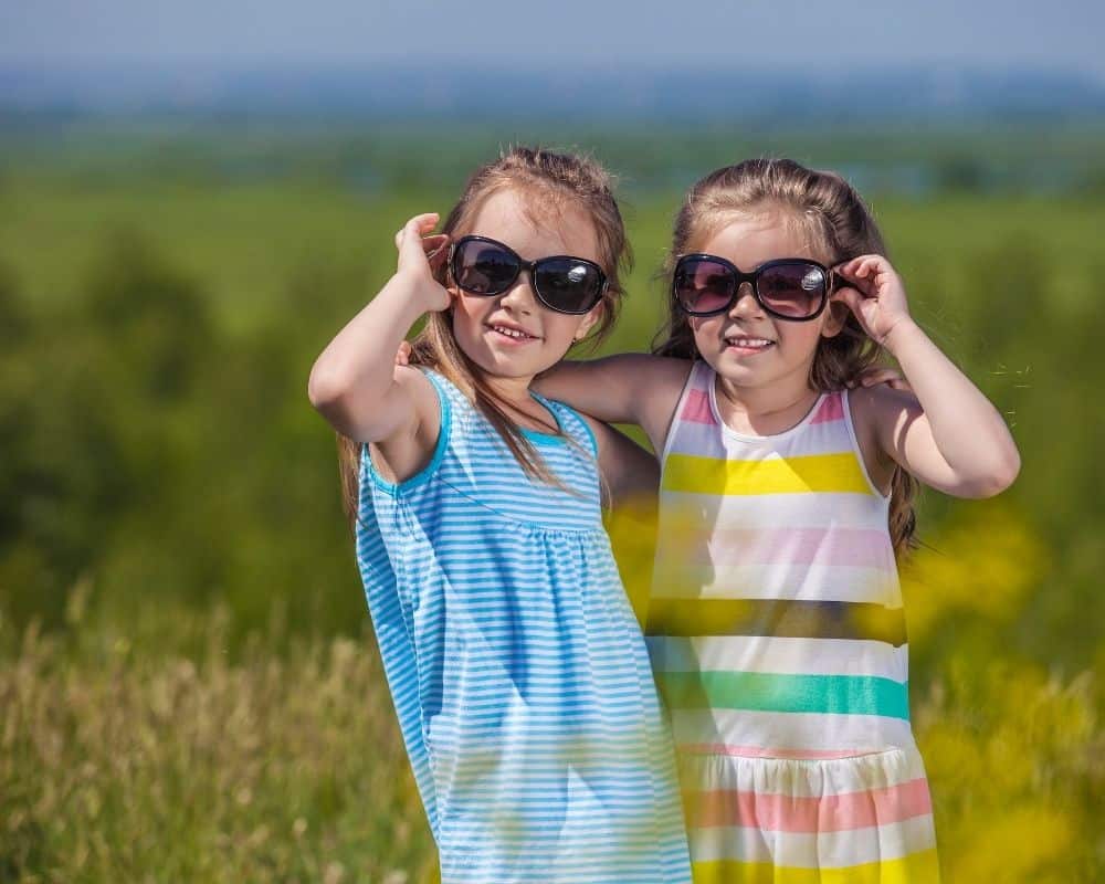 To jenter med solbriller ute i naturen
